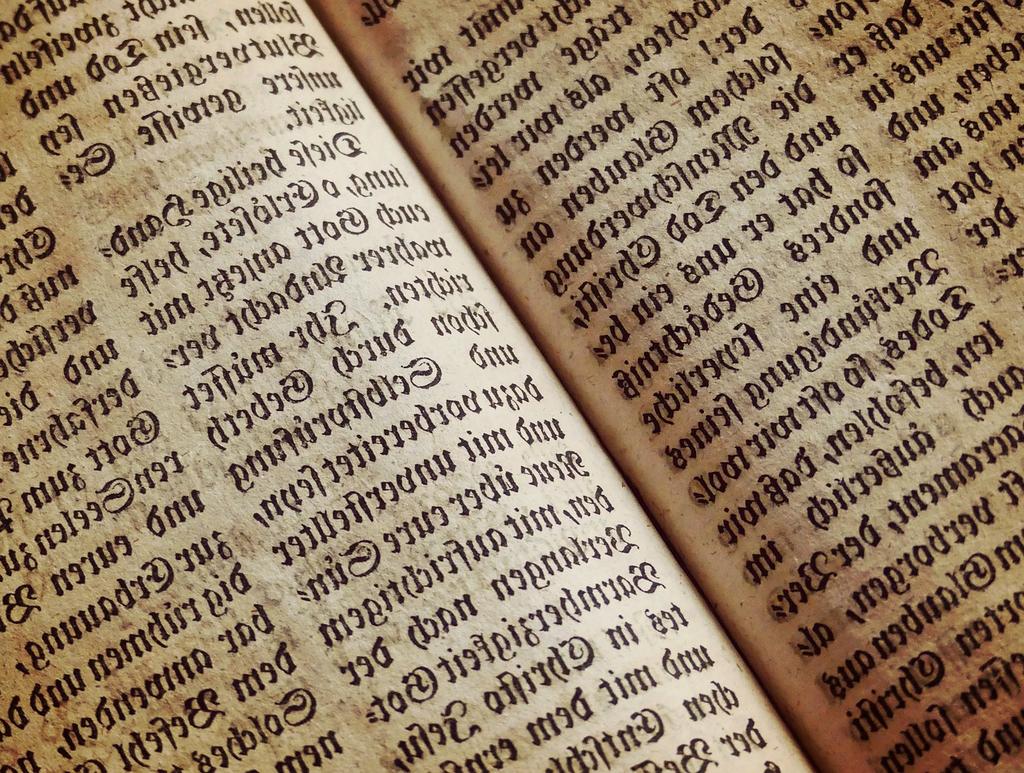 Stack of computing books and digital devices on desk